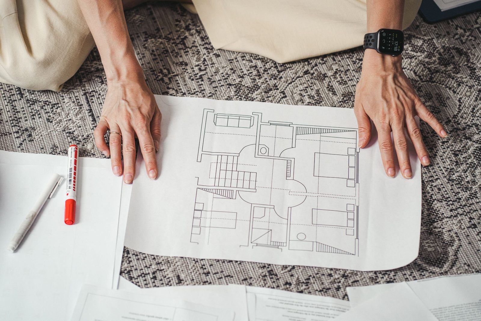 Hands laid over a printed architectural floor plan on a work surface